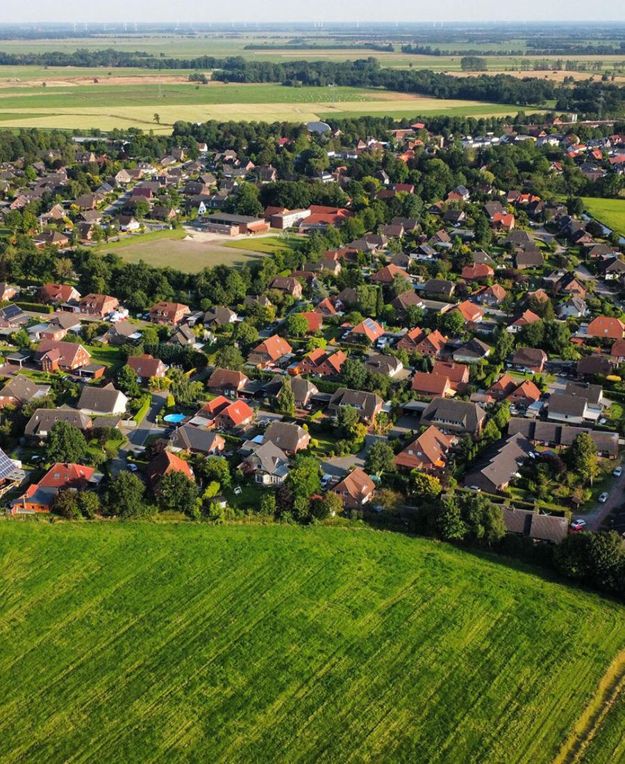 Großenmeer von oben: Häuser und Bäume inmitten grüner Marschwiesen